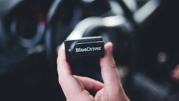a hand holding a black device