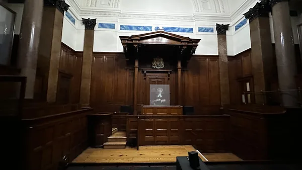 an empty courtroom with wooden paneling and columns