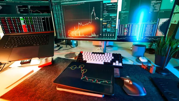 A trader's desk is lit up with charts.