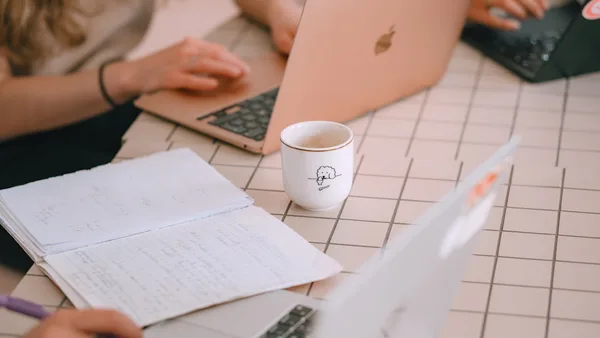 People working on laptops with notebooks and notebooks.