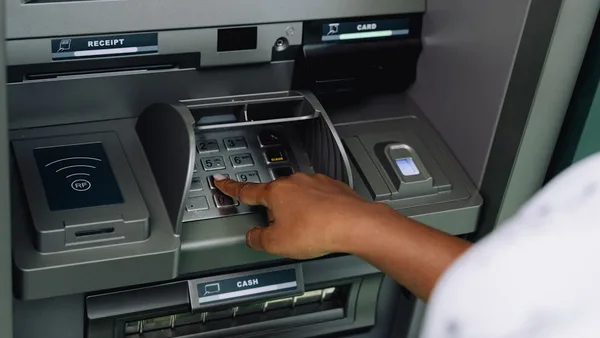a person using an atm machine to pay money