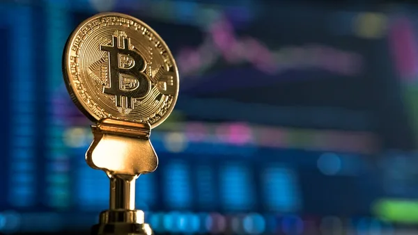selective focus photo of Bitcoin near monitor