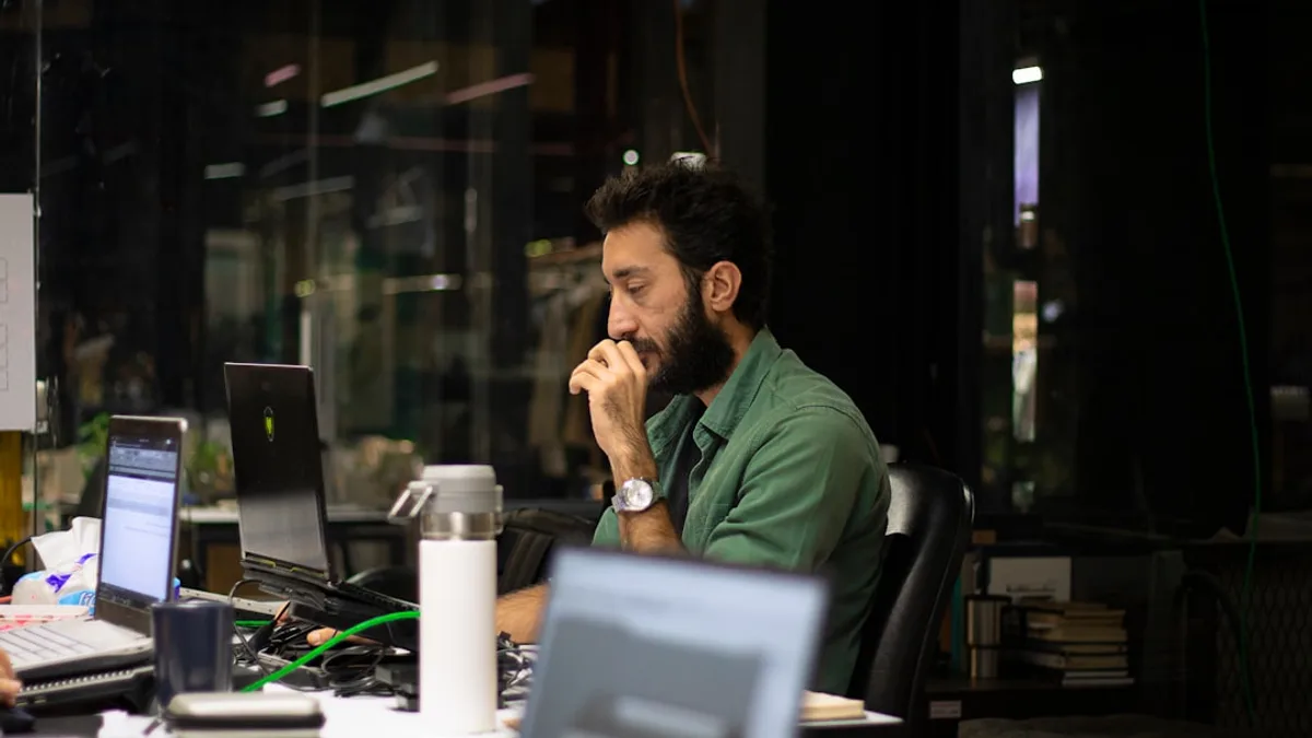 a man sitting in front of a laptop computer