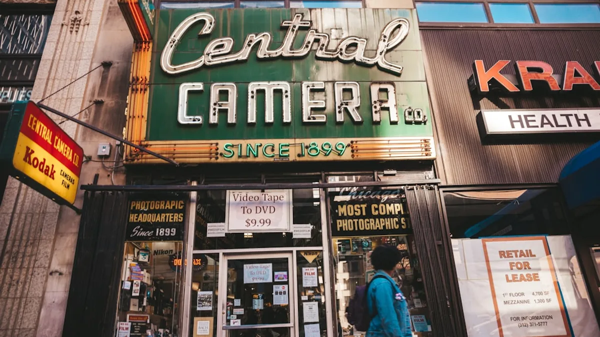 person standing beside Central Camera store-front