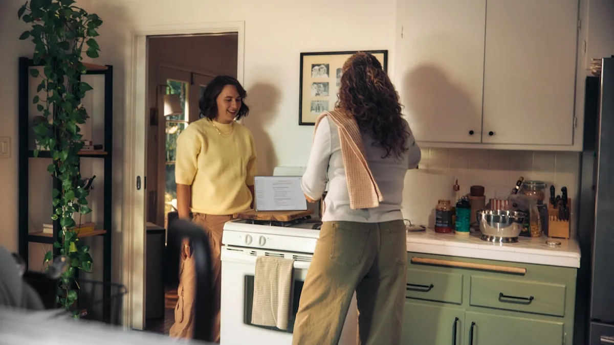 Two women talking in a kitchen while cooking