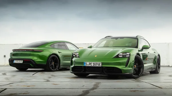 a pair of green sports cars parked next to each other