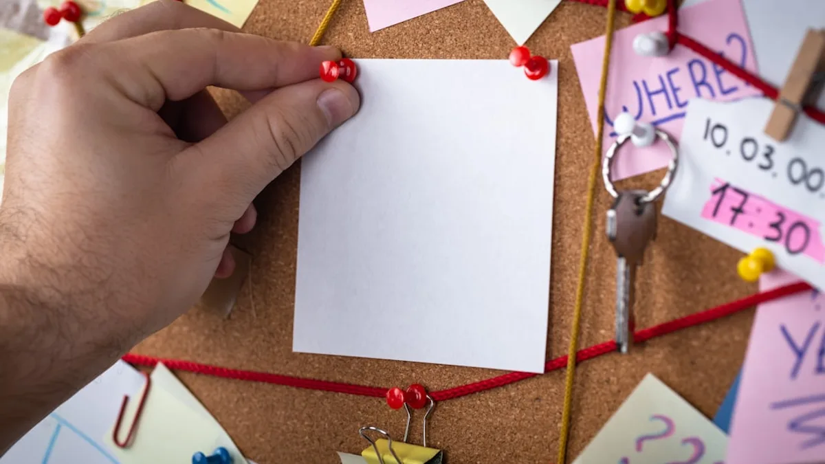 shallow focus photo of white paper sheet mounted on cork board