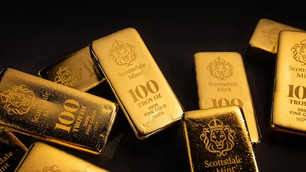 Several gold bars scattered on a dark surface.