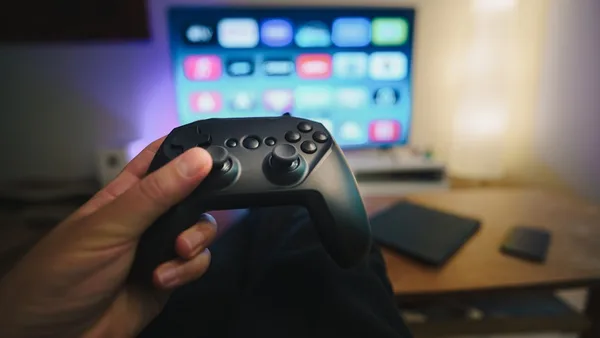 A person holding a video game controller in front of a computer