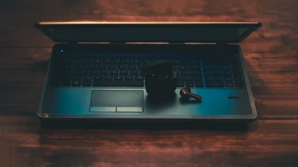 black and gray laptop computer with black corded mouse on brown wooden table