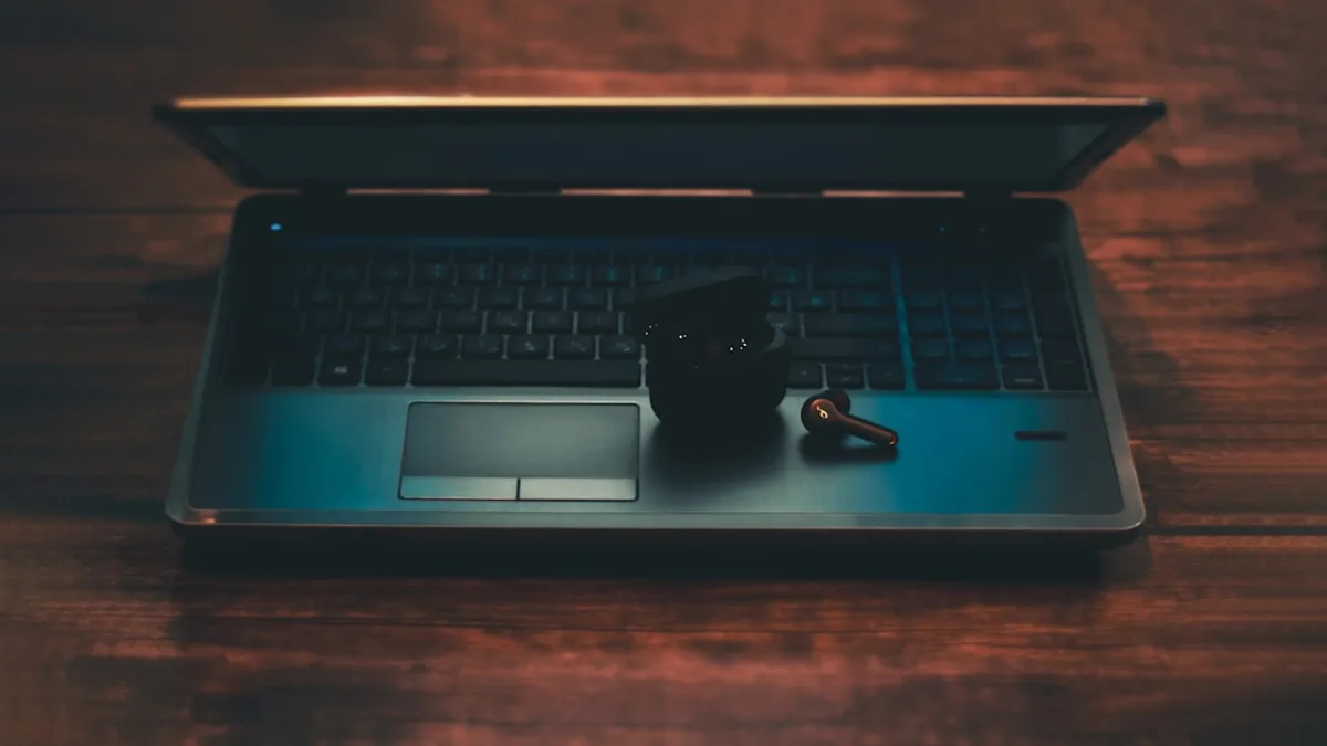 black and gray laptop computer with black corded mouse on brown wooden table
