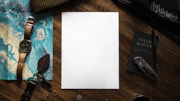 a notepad sitting on top of a wooden table next to a pair of scissors