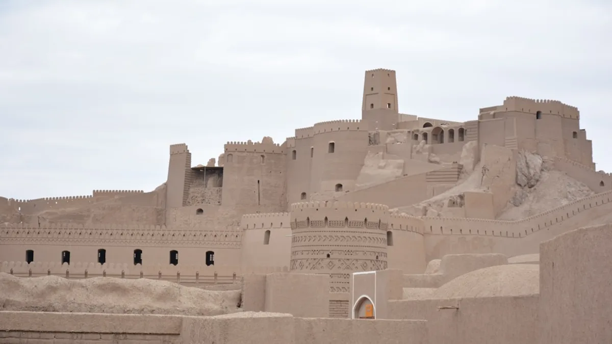 Ancient desert fortress with towers under a cloudy sky