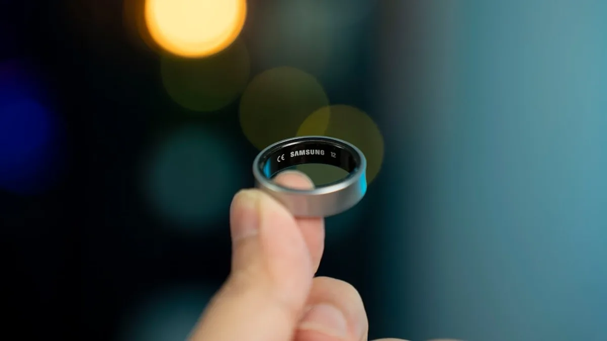 A hand is holding a smart ring.