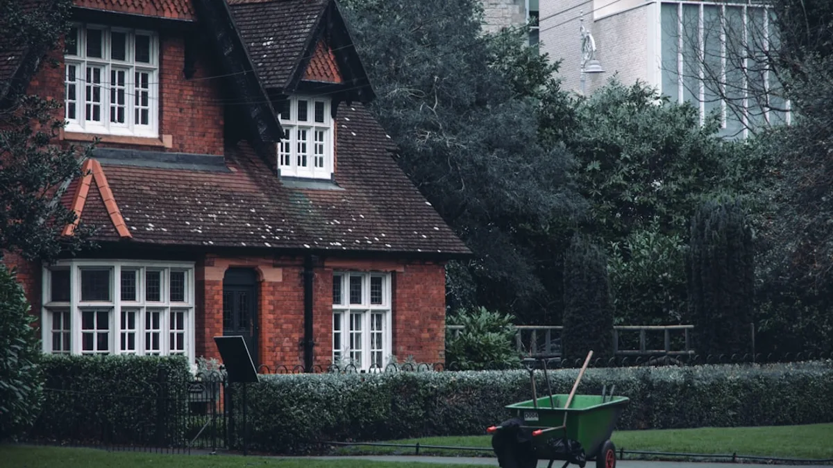A red brick house with a green garden cart outside