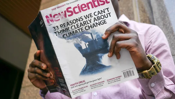 man reading New Scientist book
