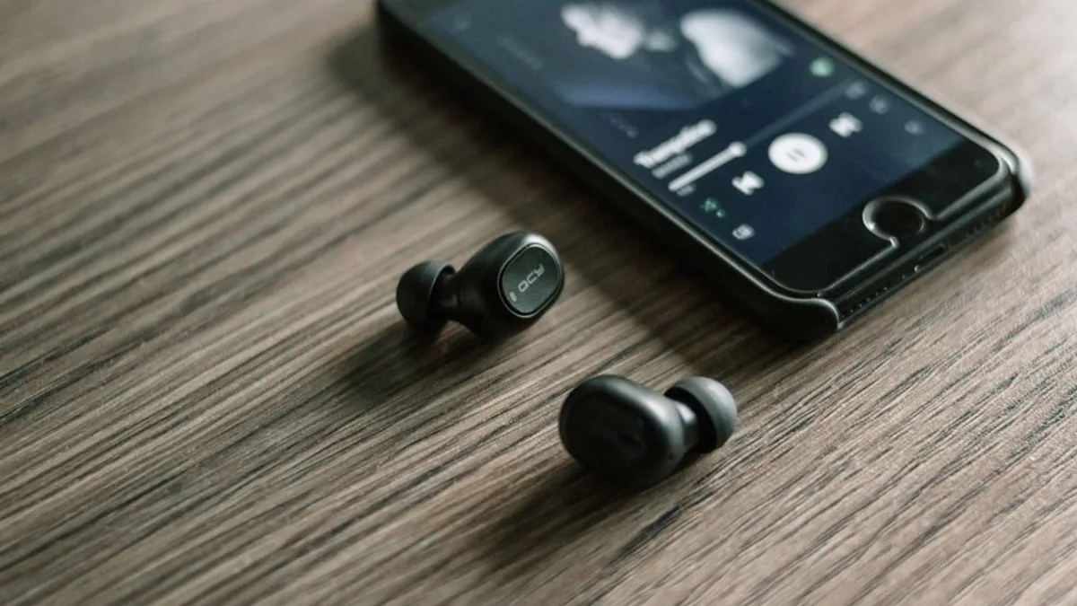 pair of Bluetooth earphones beside phone