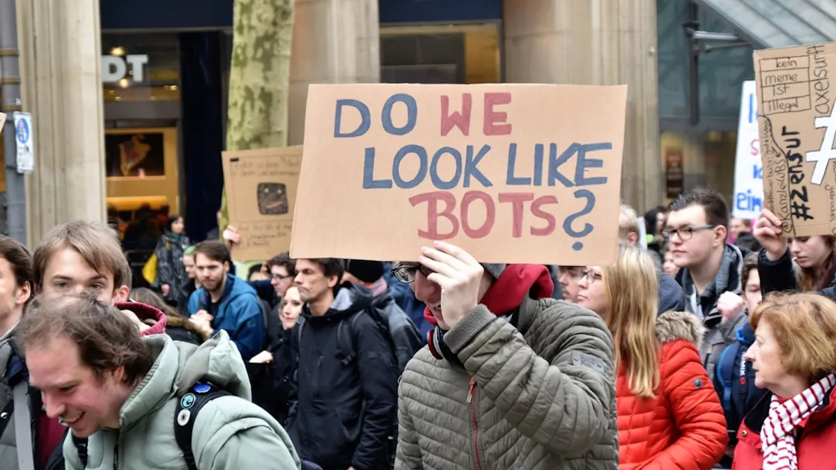 woman holding cardboard box with do we look like bots ? text
