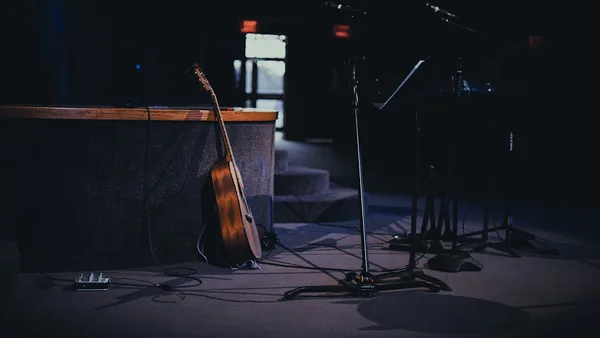 a guitar and a microphone in a dark room