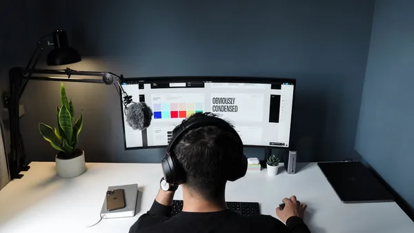 man in black shirt sitting in front of computer