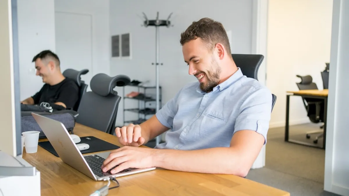 a man sitting in front of a laptop computer