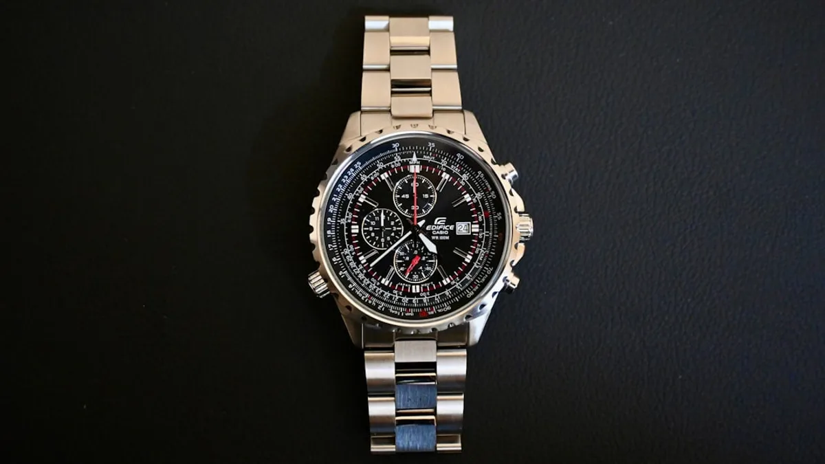 a watch sitting on top of a metal bracelet