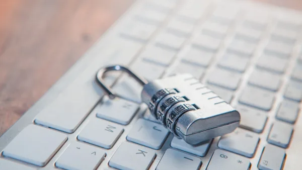 A combination lock rests on a computer keyboard.