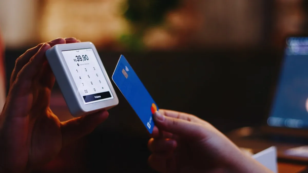 a person holding a credit card and a cell phone