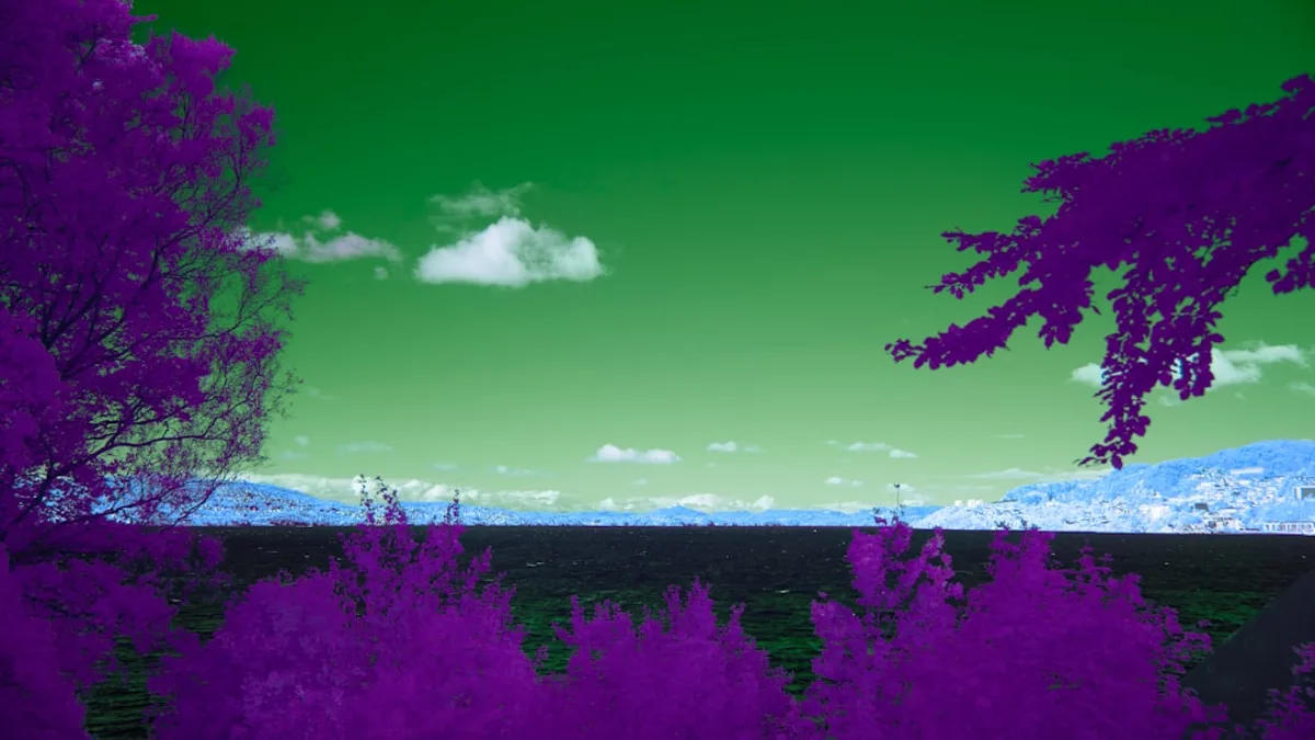 Purple trees and green sky over blue mountains