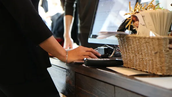 person in black long sleeve shirt holding black computer keyboard