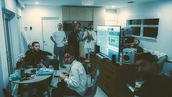 a group of people standing and sitting around a living room