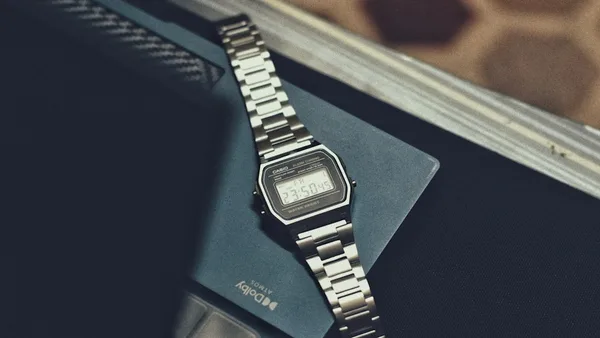 a watch sitting on top of a book on a table