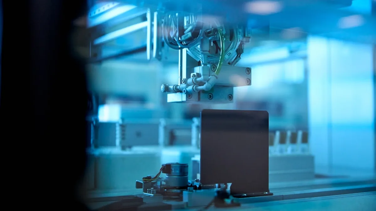 industrial robotic arm in blue lit factory