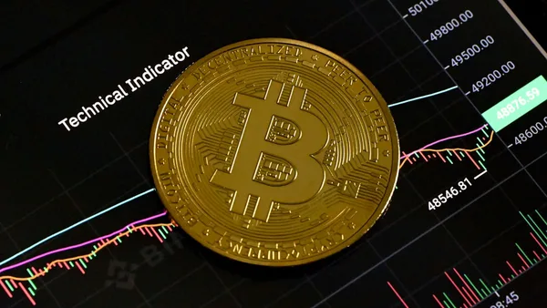 a bit coin sitting on top of a stock chart