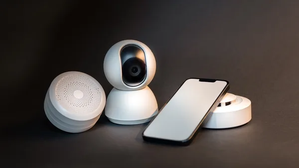 a smart phone sitting next to a wireless security camera