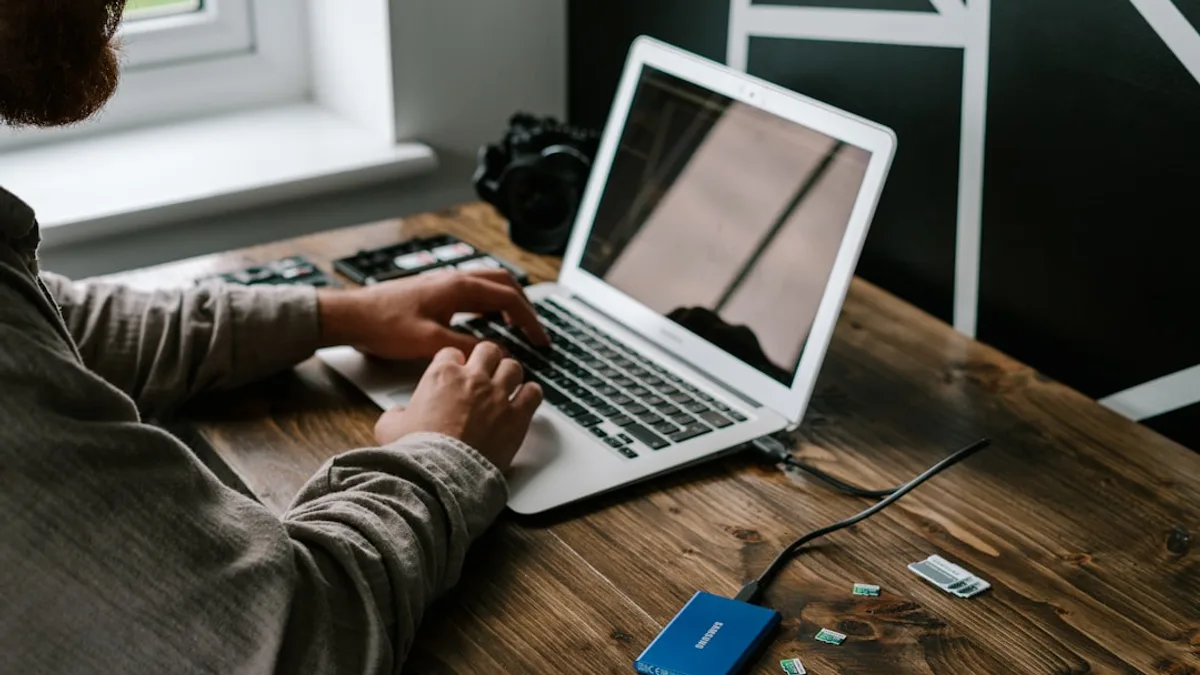 person in gray long sleeve shirt using macbook air on brown wooden table