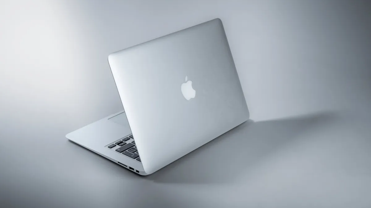 silver macbook on white table