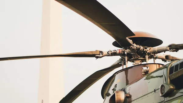 A close up of a military helicopter flying in the sky