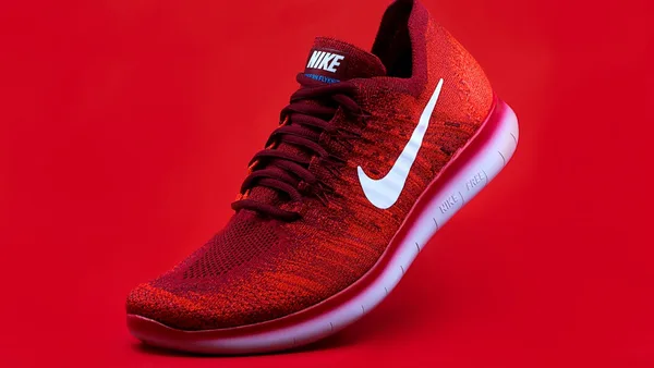 unpaired red Nike sneaker
