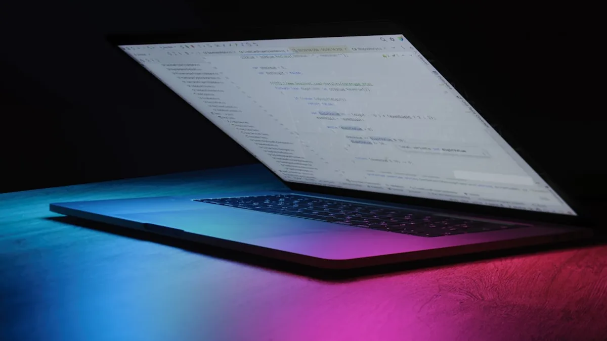 Open laptop with code on screen, neon lighting