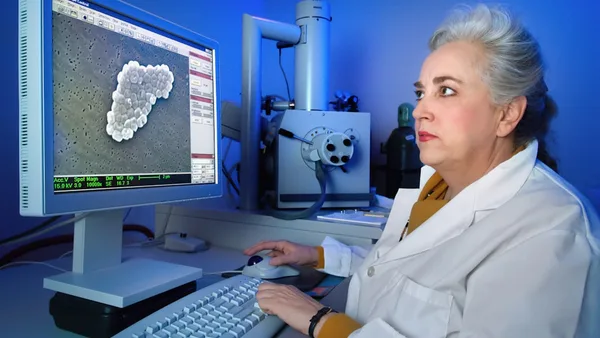 a woman sitting in front of a computer monitor