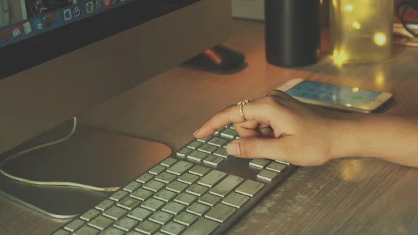 a person typing on a keyboard on a desk
