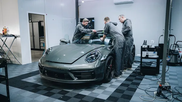 a group of men working on a car in a garage