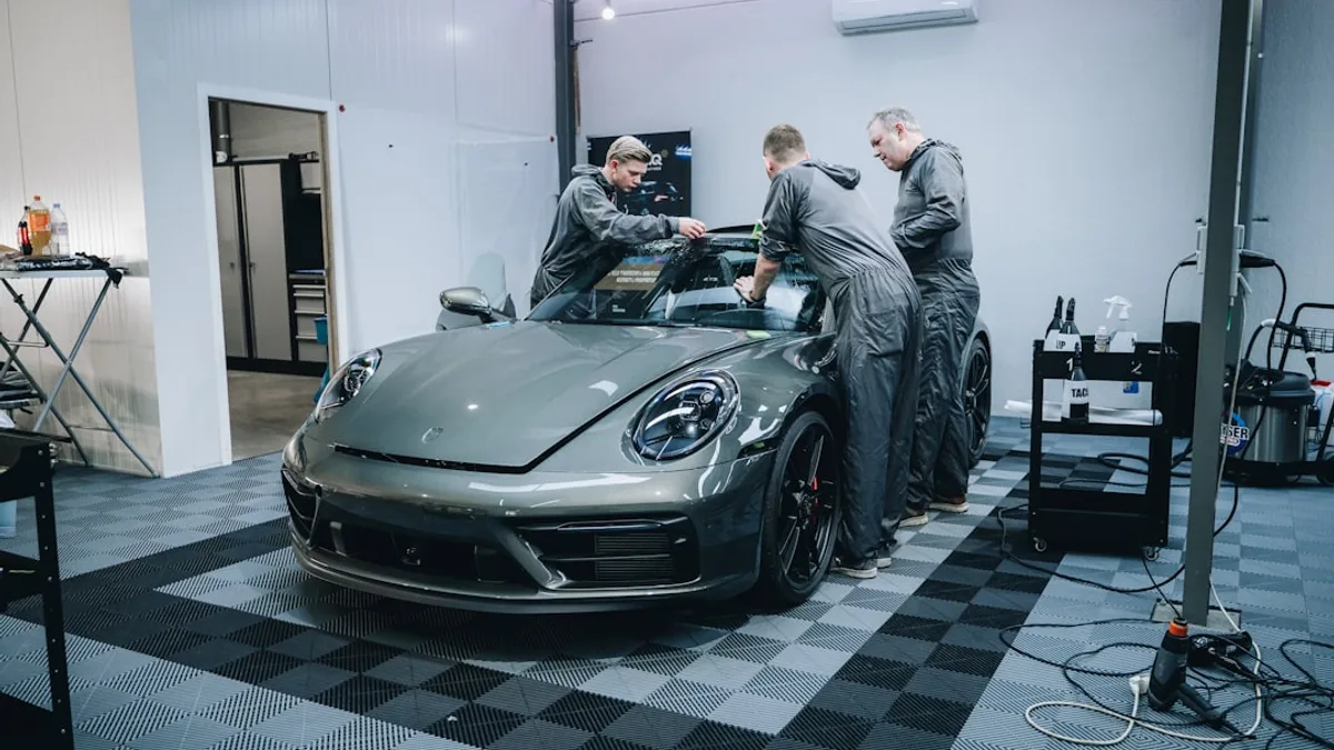 a group of men working on a car in a garage