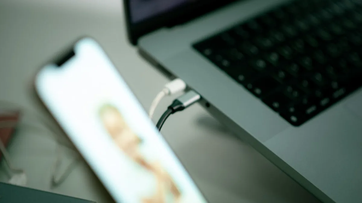 a close up of a cell phone near a laptop
