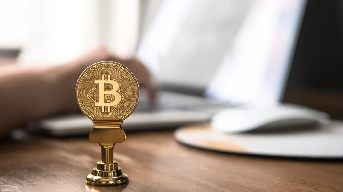 gold-colored bitcoin on brown table