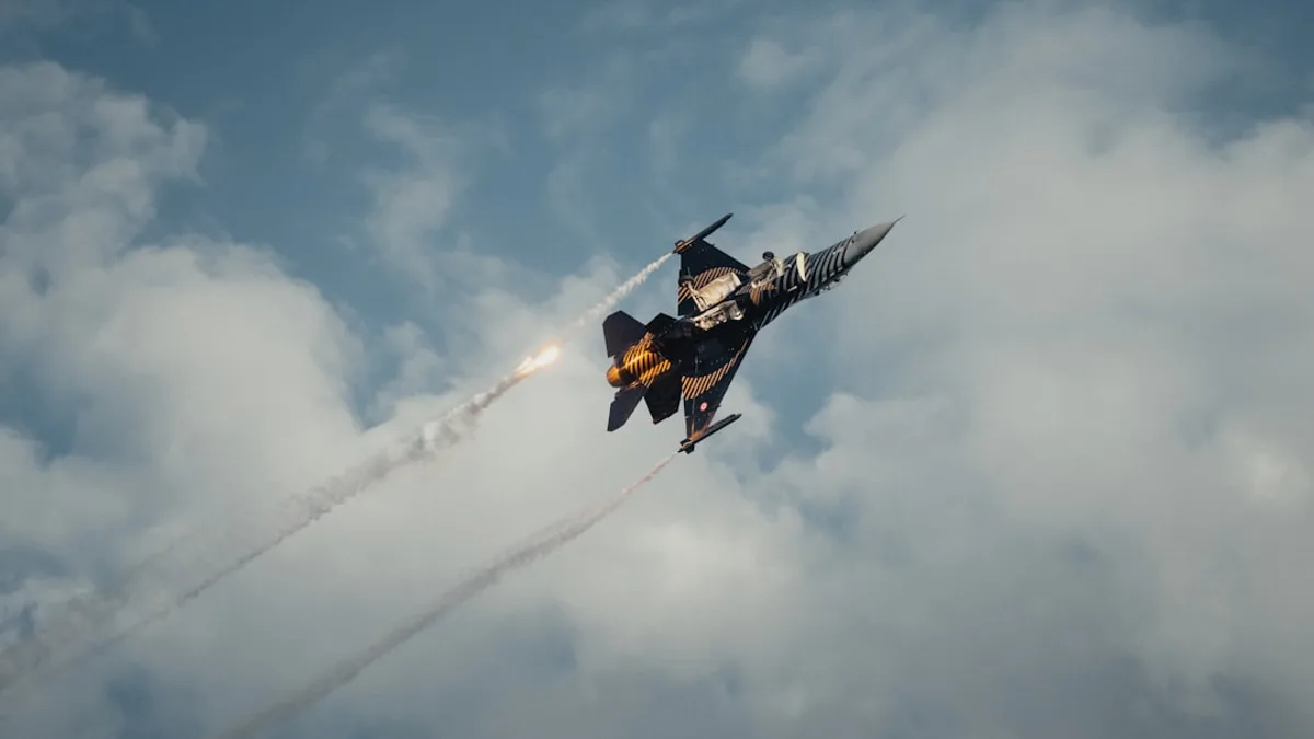 A fighter jet flying through a cloudy blue sky