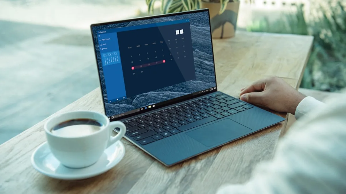 person using black laptop computer on brown wooden table