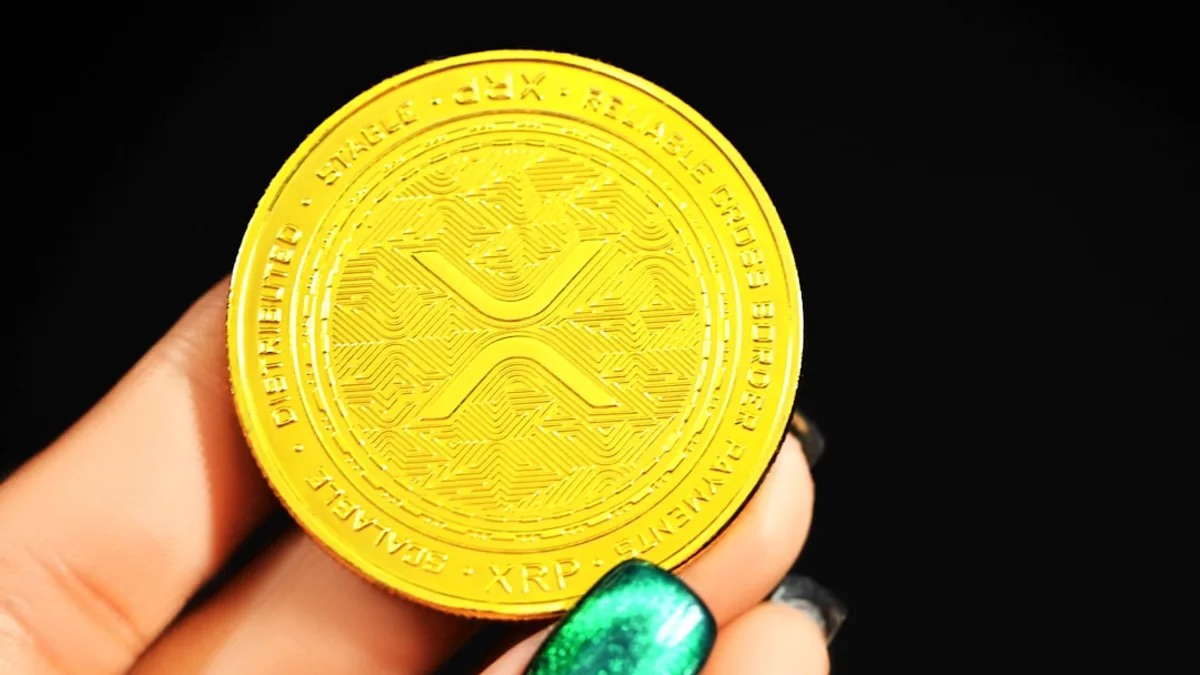 gold round coin on persons hand