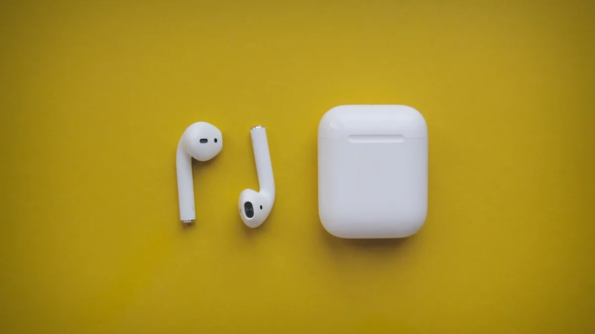 white apple airpods on yellow surface